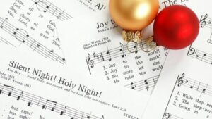 Christmas Carol sheet music with a couple of Christmas ornaments